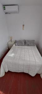 a bed in a bedroom with a white comforter at A la sombra del calden in Santa Rosa