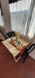 una mesa de madera con platos y cuencos en A la sombra del calden en Santa Rosa