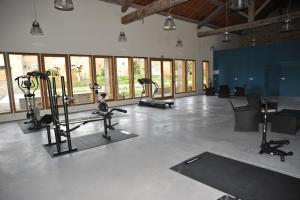 a gym with treadmills and ellipticals in a room with windows at Domaine de Ceyrac in Conqueyrac