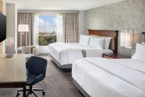 um quarto de hotel com duas camas e uma secretária em The Westin Atlanta Perimeter North em Atlanta