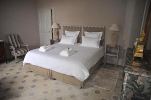 a bedroom with a large white bed with two towels on it at Domaine de Ceyrac in Conqueyrac +26 photos