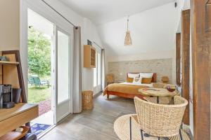 a bedroom with a bed and a table and chairs at L'Orée de Giverny in Limetz