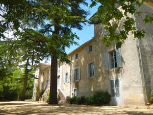 an old building with trees in front of it at Domaine de Ceyrac in Conqueyrac