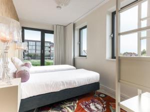 a bedroom with two beds and windows at Apartment Kamperland with Harbour View in Kamperland