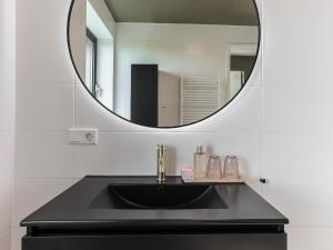 a bathroom with a black sink and a mirror at Apartment Kamperland with Harbour View in Kamperland +32 photos