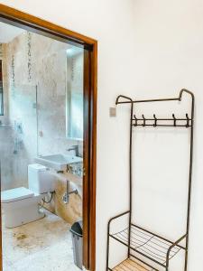 bagno con doccia, lavandino e specchio di De Summit Villa & View a Puncak