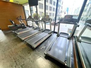 a gym with rows of tread machines in a room at Lovely 45 sqm 1-Br Knightsbridge Residences Wi-Fi/Netflix/HBO in Manila