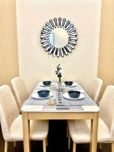una mesa con sillas y un espejo en la pared en Lovely 45 sqm 1-Br Knightsbridge Residences Wi-Fi/Netflix/HBO en Manila