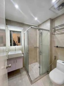 a bathroom with a shower and a toilet and a sink at Lovely 45 sqm 1-Br Knightsbridge Residences Wi-Fi/Netflix/HBO in Manila