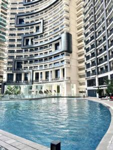a large building with a large swimming pool in front of it at Lovely 45 sqm 1-Br Knightsbridge Residences Wi-Fi/Netflix/HBO in Manila