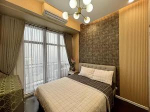 a bedroom with a bed and a large window at Lovely 45 sqm 1-Br Knightsbridge Residences Wi-Fi/Netflix/HBO in Manila