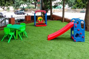 a playground with a slide and a table on the grass at Super Collection O 9133 The Olive Star in Mysore