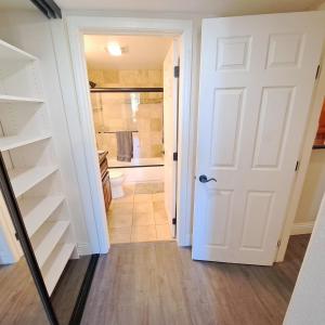 a hallway with a white door and a bathroom at Venetian La Jolla 2 bedroom condo luxury furnished near beach and UTC mall in San Diego