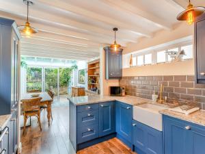a kitchen with blue cabinets and a dining room at Murton House in Osmotherley