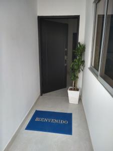 un tappetino blu di benvenuto sul pavimento di fronte a una porta di Casa Mompox a Mompós