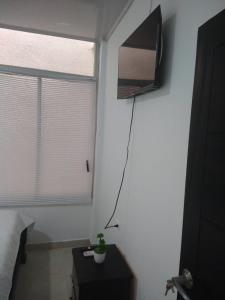een kamer met een tv aan de muur en een tafel bij Casa Mompox in Mompos