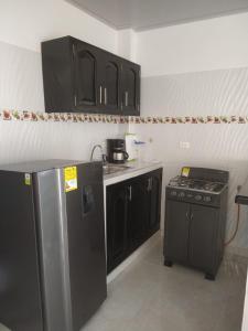 een keuken met zwarte kasten en een zwarte koelkast bij Casa Mompox in Mompos