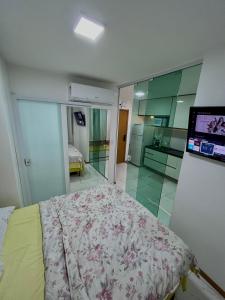 sypialnia z łóżkiem i telewizorem na ścianie w obiekcie Smart Itapuä w mieście Salvador