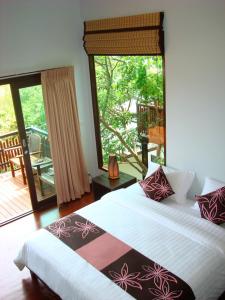 a bedroom with a large bed and a balcony at Chintakiri Resort in Koh Tao