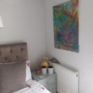 a bedroom with a bed and a painting on the wall at Hideaway Cottage - Private ensuite room - 4 minutes to the sea! in Sandgate
