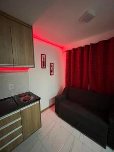 salon z kanapą i czerwonym światłem w obiekcie Smart Itapuä w mieście Salvador