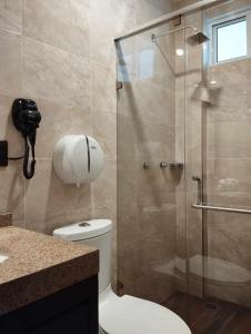 a bathroom with a toilet and a glass shower at Hotel & Cabañas Malinche in Huamantla