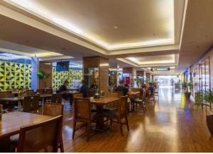 a restaurant with tables and chairs and people sitting at tables at S4 Hotel Águas claras flat particular fora do pool in Brasilia