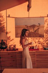 a woman in a white dress standing in a room at Enkusero Mara in Aitong