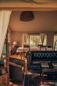 a living room with a leather couch and a table at Enkusero Mara in Aitong