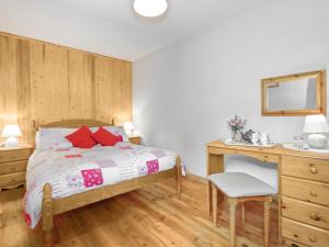 una camera con letto, scrivania e specchio di Inglenook Cottage a Landshipping
