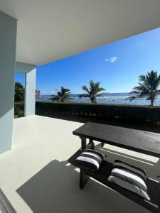 a patio with a bench and a view of the beach at Coast Cook Islands in Rarotonga
