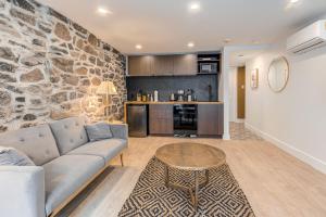 a living room with a couch and a stone wall at Elegant 1 Bedroom Suite in Quebec City