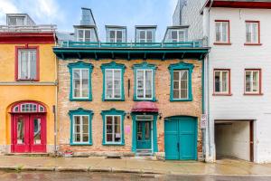 魁北克市的住宿－Elegant 1 Bedroom Suite，拥有蓝色门窗的砖砌建筑