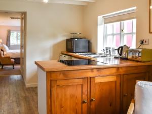 a kitchen with a counter with a microwave and a sink at Little House On The Common in Wortham