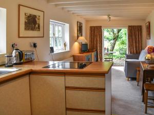 a kitchen with a counter top and a living room at Little House On The Common in Wortham