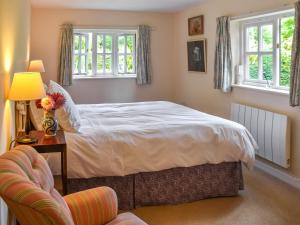 a bedroom with a bed and a table and a chair at Little House On The Common in Wortham