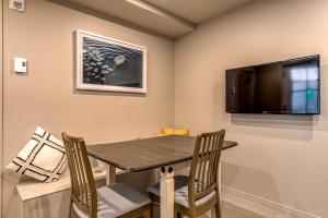 Quebec 2 Bedroom Apartment في مدينة كيبك: غرفة طعام مع طاولة وتلفزيون بشاشة مسطحة