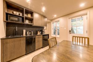 a kitchen with a wooden table and a microwave at North House - Two bedroom Escape in the Heart of Old Quebec in Quebec City +10 photos