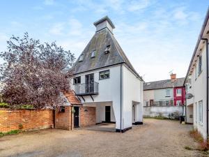 an old brick building with a tower on top of it at The Oast House in Saffron Walden