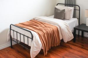 Una cama con una manta naranja encima. en Conveniently located 2bd-LAX-Sofi Stadium-Space X, en Inglewood