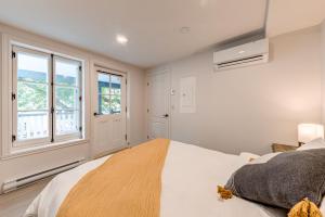 una camera da letto con un grande letto bianco e finestre di Quebec City 2 Bedroom Treasure a Québec