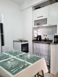 a kitchen with a table with glass plates on it at Apartamento no Centro de Cabo Frio in Cabo Frio