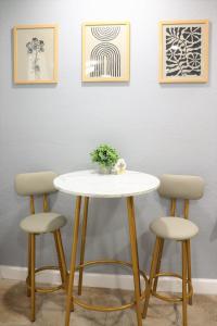 a table and two stools against a wall with paintings at Luxury Studio Suite close to Tampa Airport in Tampa
