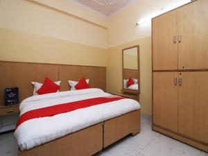 - une chambre avec un grand lit et des oreillers rouges dans l'établissement OYO 24103 AKBAR PALACE, à Aligarh