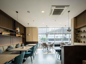 a restaurant with tables and chairs and a large window at Cove The Day in Jakarta