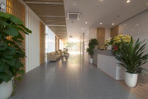 um corredor com plantas e flores num edifício em Elite Hotel em Ha Long