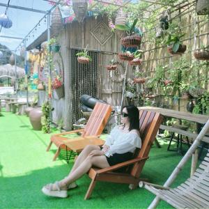 una mujer sentada en una silla sobre el césped en Hang Mua Bungalow, en Ninh Binh
