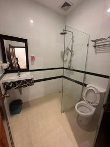 ルアンパバーンにあるヴィラ マハソク ホテルのバスルーム(ガラス張りのシャワー、トイレ付)