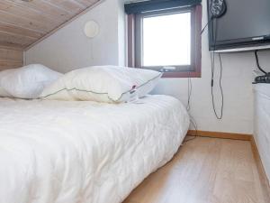 1 dormitorio con 1 cama blanca y TV en la pared en Holiday home Nordborg XXVII, en Nordborg