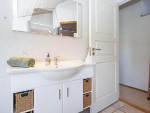 La salle de bains est pourvue d'un lavabo blanc et d'un miroir. dans l'établissement Holiday home Nordborg XXVII, à Nordborg
